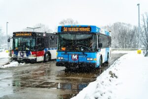 Photo of two Metro buses on the street in the snow